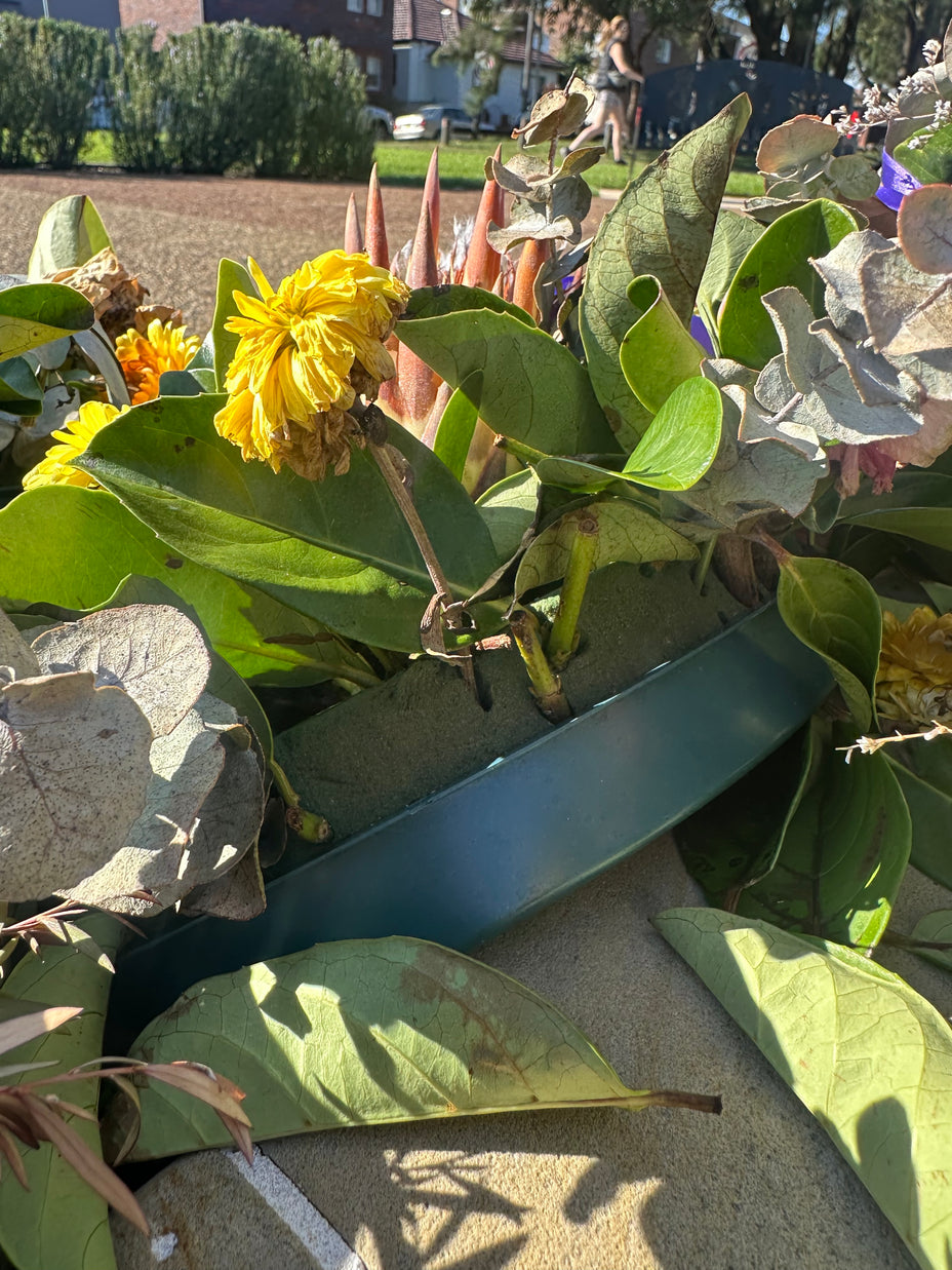 Close-up of a floral foam (single-use plastic) wreath base at a commemorative site