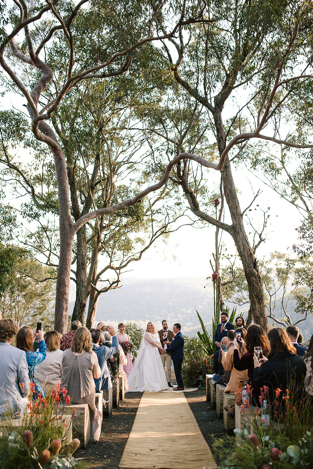 Wedding ceremony under trees with a scenic background