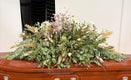 Plastic free funeral spray atop a wooden coffin