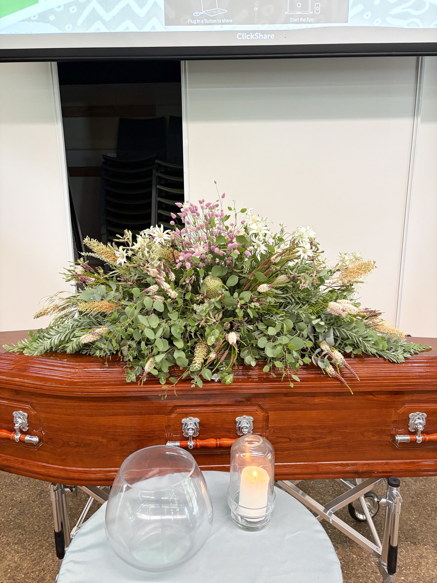Plastic free funeral spray atop a wooden coffin