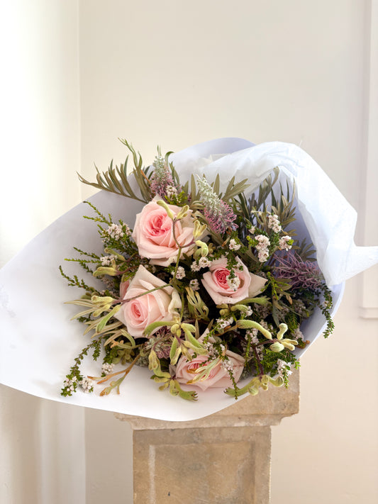 Bouquet of Australian grown pink roses and greenery on a white background