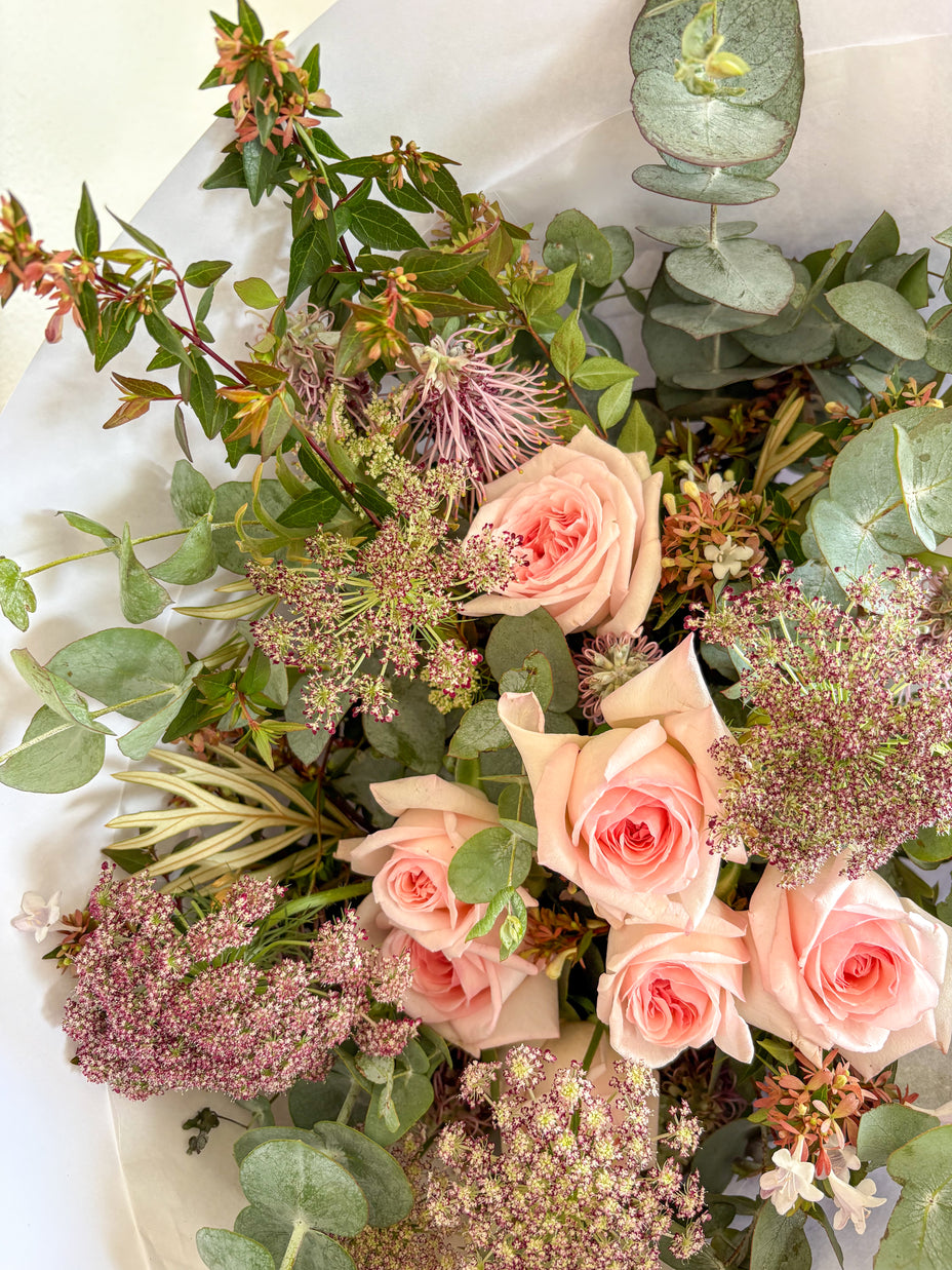 Bouquet of Australian grown pink roses and greenery on a white background